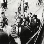00_Frantz-Fanon-sur-une-passerelle-dembarquement-de-bateau-avec-derrière-lui-Rheda-Malek-journaliste-dEl-Moudjahid-1